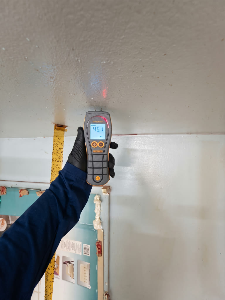 Technician holding a moisture meter at a property